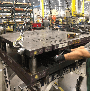 Manufacturing operator reconfiguring die press after AI-powered computer vision suggested improvements.